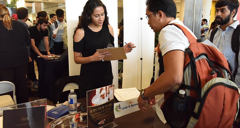 Picture of student in front of an employer booth during a job fair
